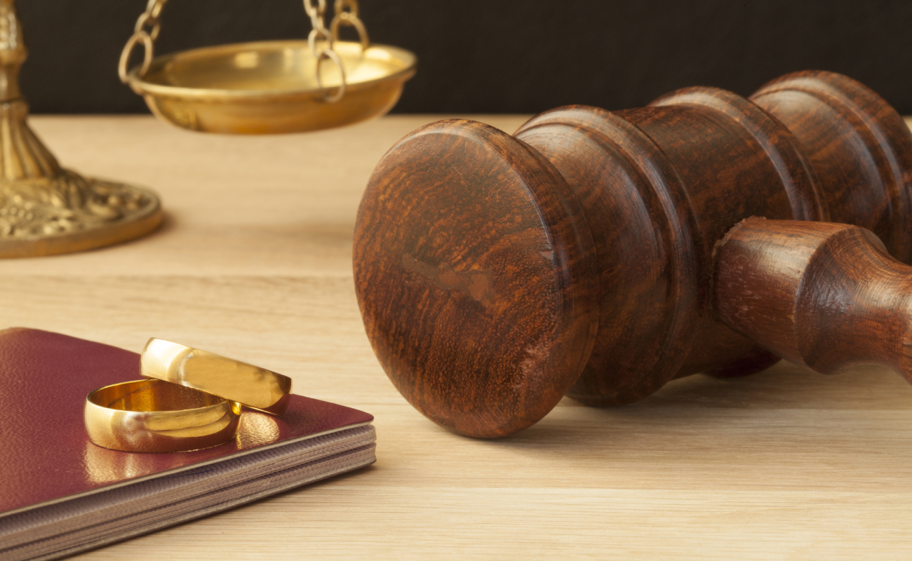 gavel, wedding rings, and scales of justice symbolizing divorce